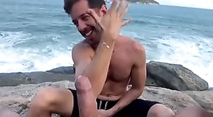 Batendo uma punheta na praia